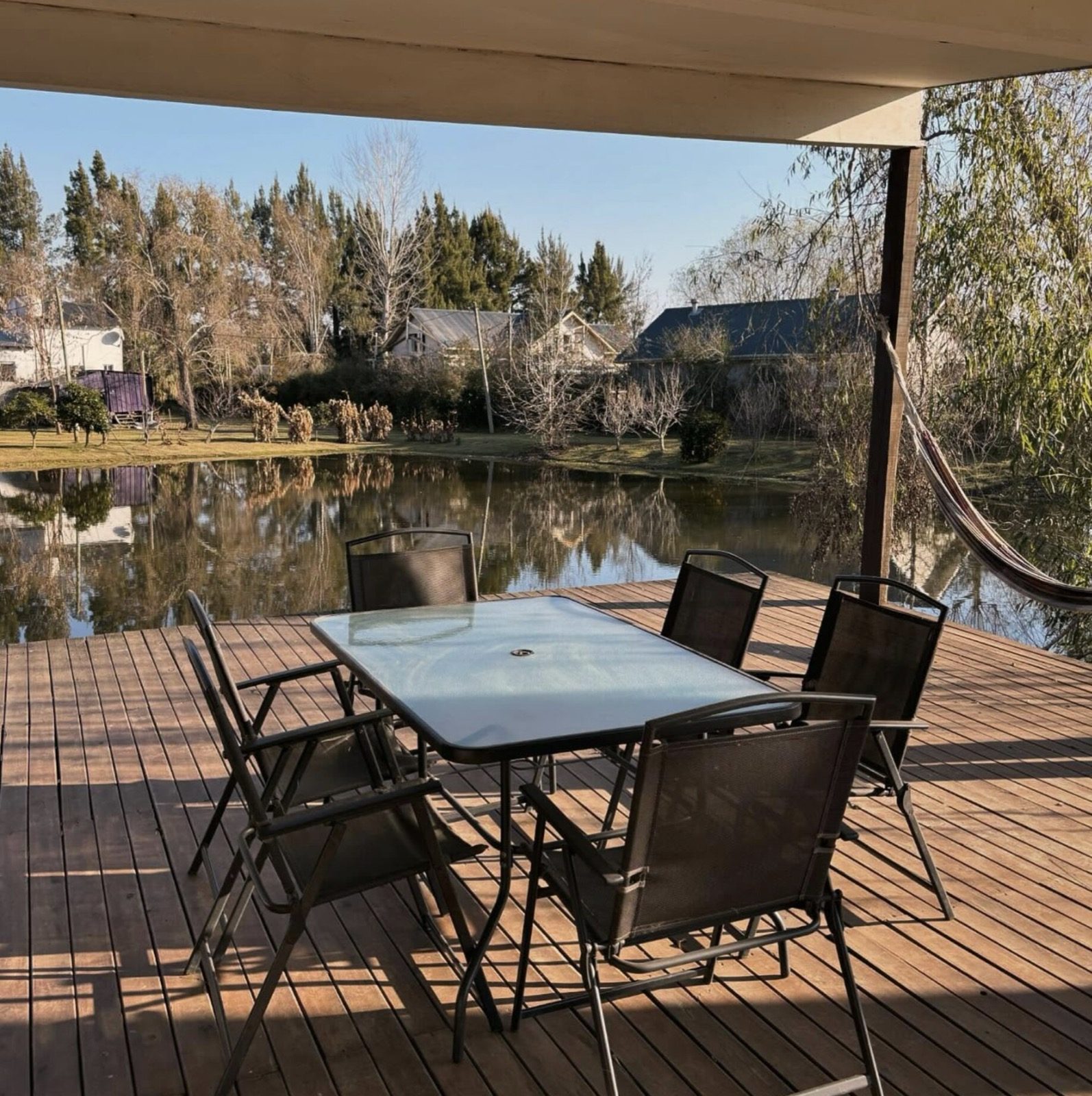 Deck techado de Casa Maui con mesa frente a la laguna