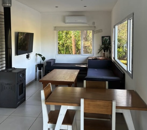 Living de Casa Maui con salamandra, Smart TV y mesa de comedor