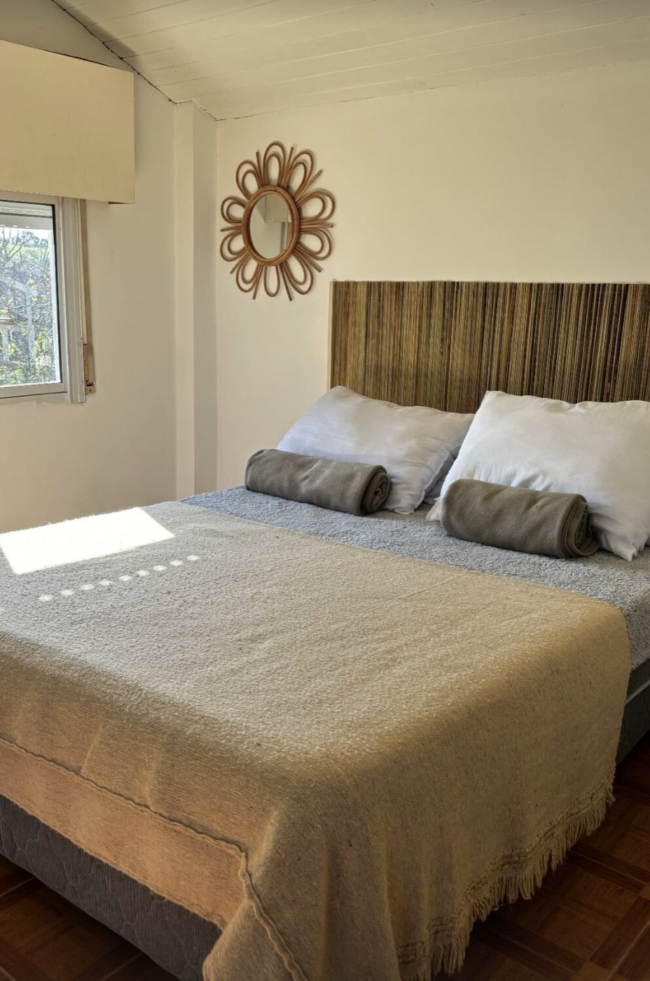 Dormitorio de Casa Pura Vida con cama doble y respaldo de madera